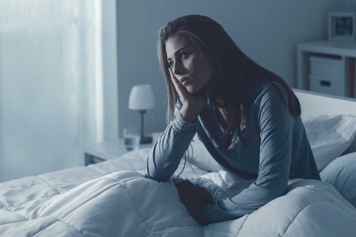 Depressed woman awake in the night, she is exhausted and suffering from insomnia